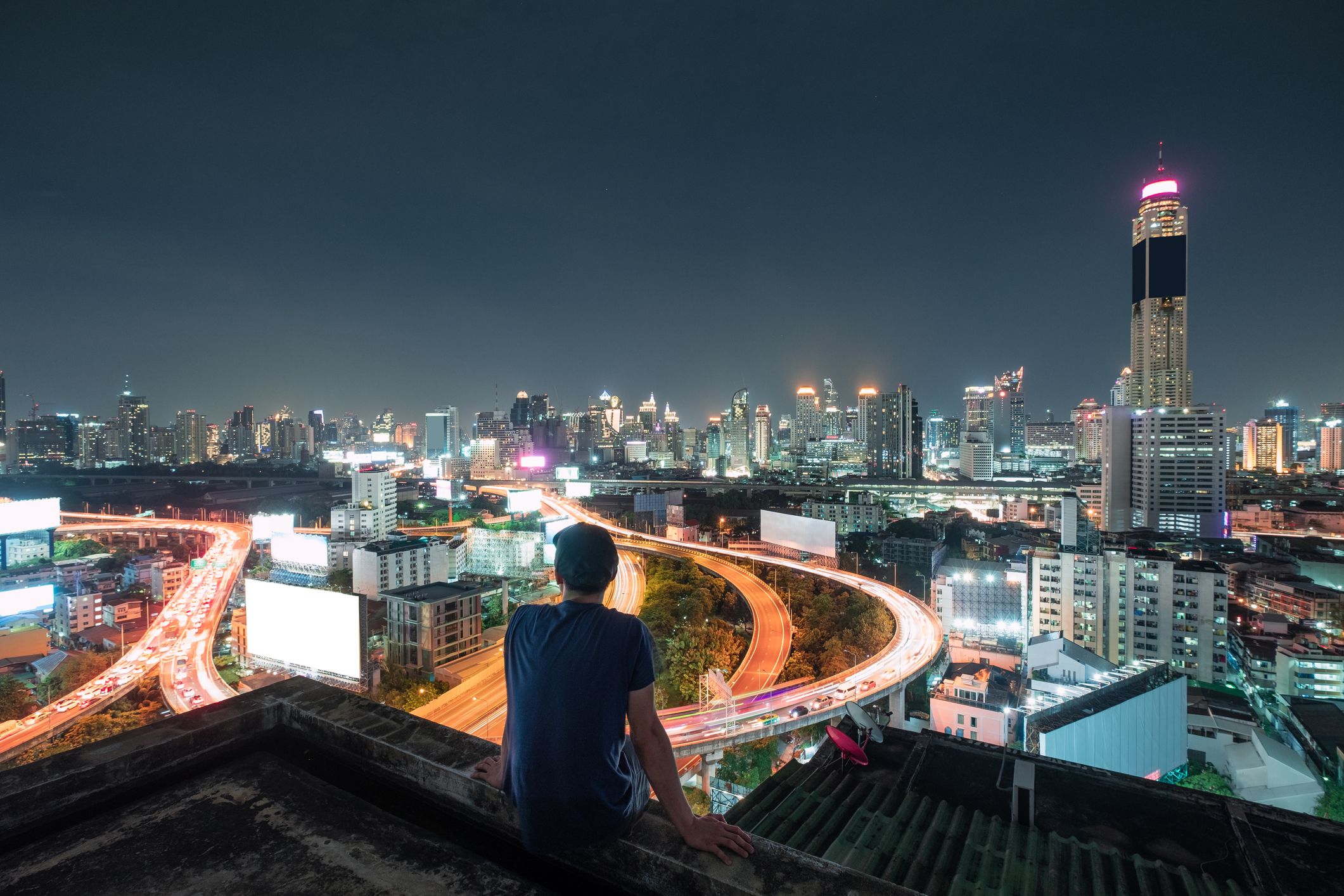 Men are sitting on balcony with sightseeing the city glowing at night